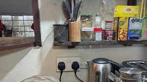 A kitchen counter with various food items, a kettle, and a coffee maker. - Hechtech House (Accra)