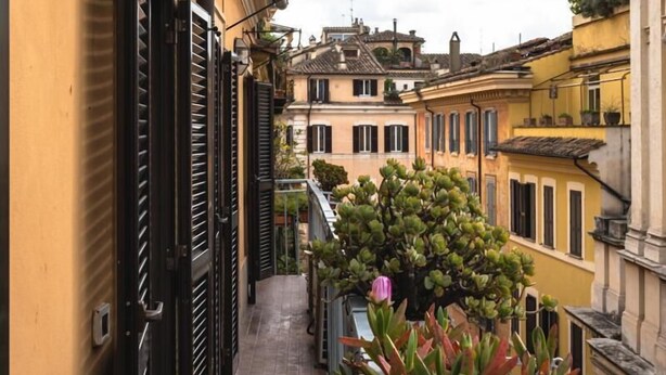 A narrow balcony with a tiled floor, a potted plant, and a metal railing. - Cesarina Home   Campo dei Fiori (ROMA)