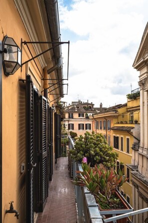 A narrow balcony with a tiled floor, a potted plant, and a metal railing. - Cesarina Home   Campo dei Fiori (ROMA)