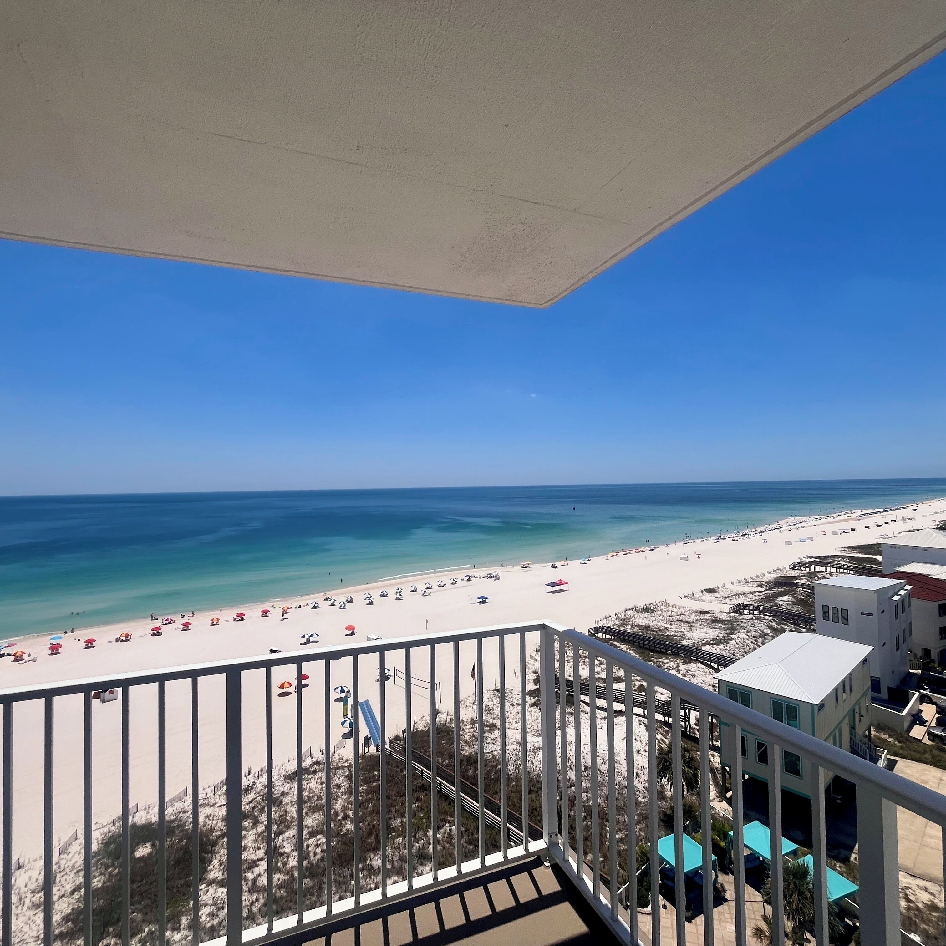 Ein Balkon mit Blick auf Strand und Meer.