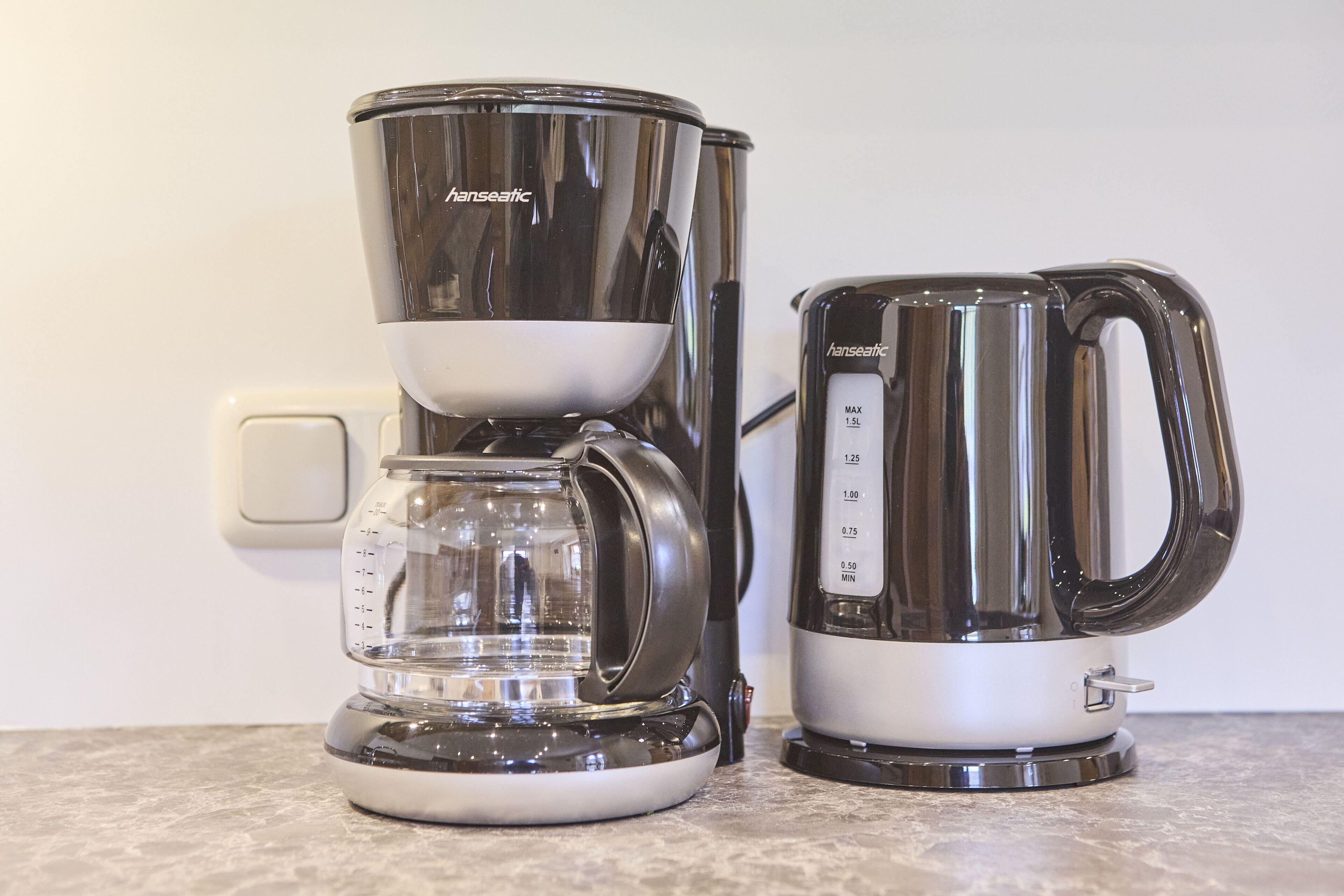 Eine Kaffeemaschine mit einer transparenten Kanne und einem separaten Zubereiter, beide mit dem Markennamen 'hanseatic'.