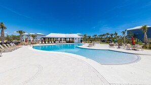 Una piscina con sillas de descanso y una zona de estar cubierta.
