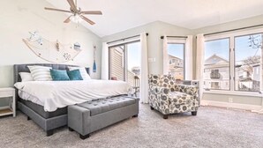 Um quarto com uma cama, uma cadeira e um ventilador de teto.