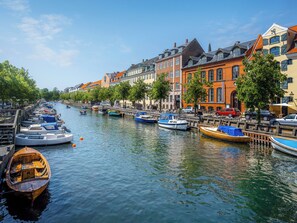 A canal lined with colorful buildings and boats docked along the water. - Leaves 6 - 2 Bdr Apt With Shared Roof Terrace (Copenhagen)