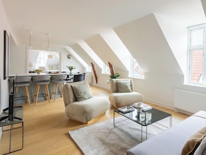 A modern loft apartment with a kitchen, dining area, and living space.