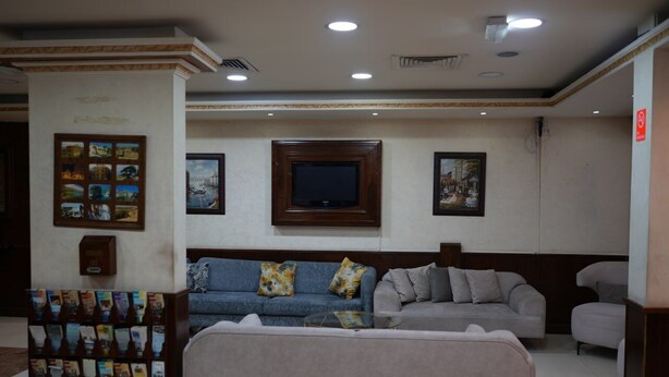 A lobby with a sofa, a television, and a magazine rack. - Elyseeresidence Hotel  (Beirut)