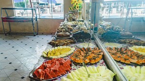 Una mesa de buffet con diversas frutas y postres.