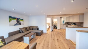 Ein modernes Wohnzimmer mit einer Couch, einem Holztisch und einem Motorradgemälde an der Wand.