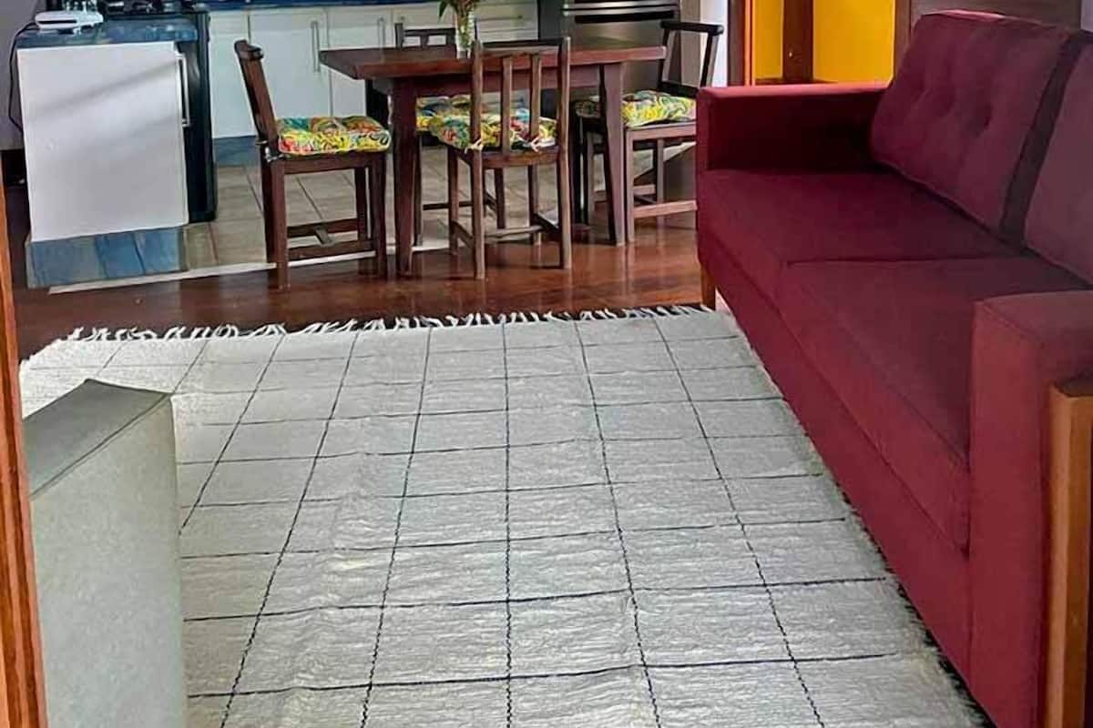 Ein kompakter Wohnraum mit Essbereich, Küche und einem roten Sofa.