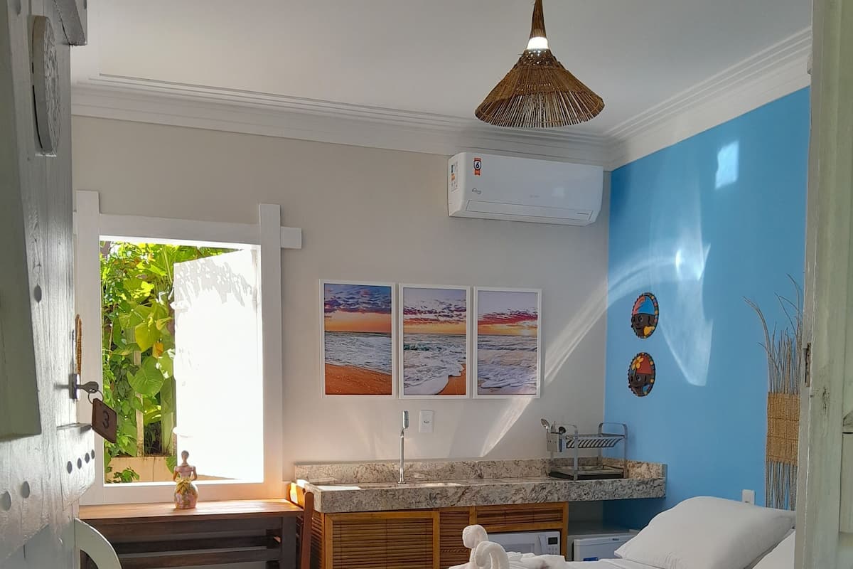 Ein Schlafzimmer mit einem Bett, einem Schreibtisch, einem Schminktisch und einer Wand mit drei gerahmten Bildern.