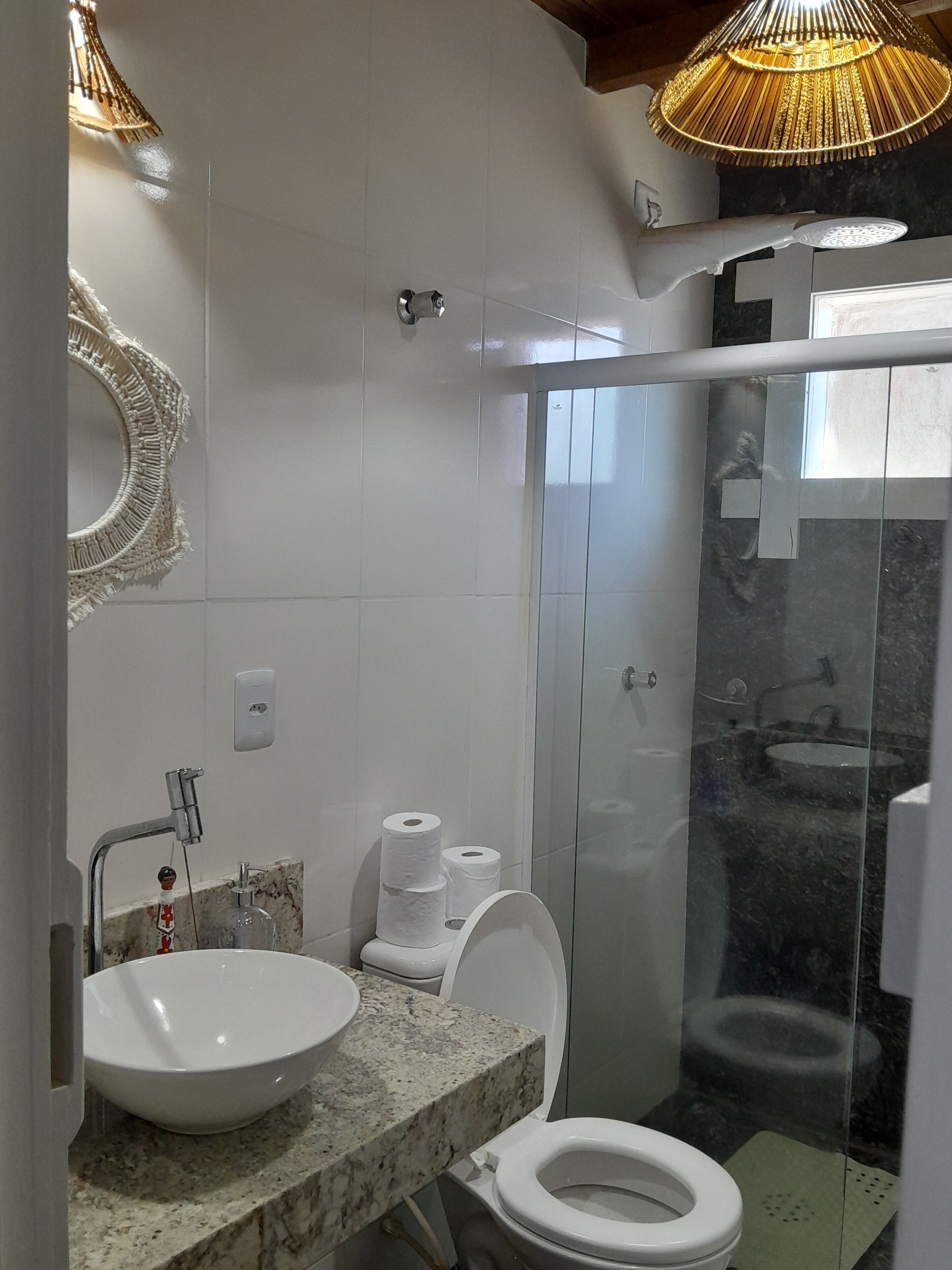 Ein modernes Badezimmer mit Waschbecken, Toilette und Duschkabine aus Glas.