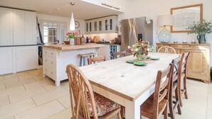 Cocina amplia con una isla central, sillas de madera y una mesa de comedor.