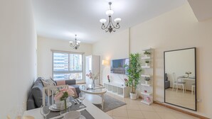A modern living room with a dining area, a large mirror, and a view of the city through a window.