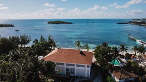 A coastal property with a beach, a pier, and boats in the water. - Guana Beach Inn (Great Guana Cay)