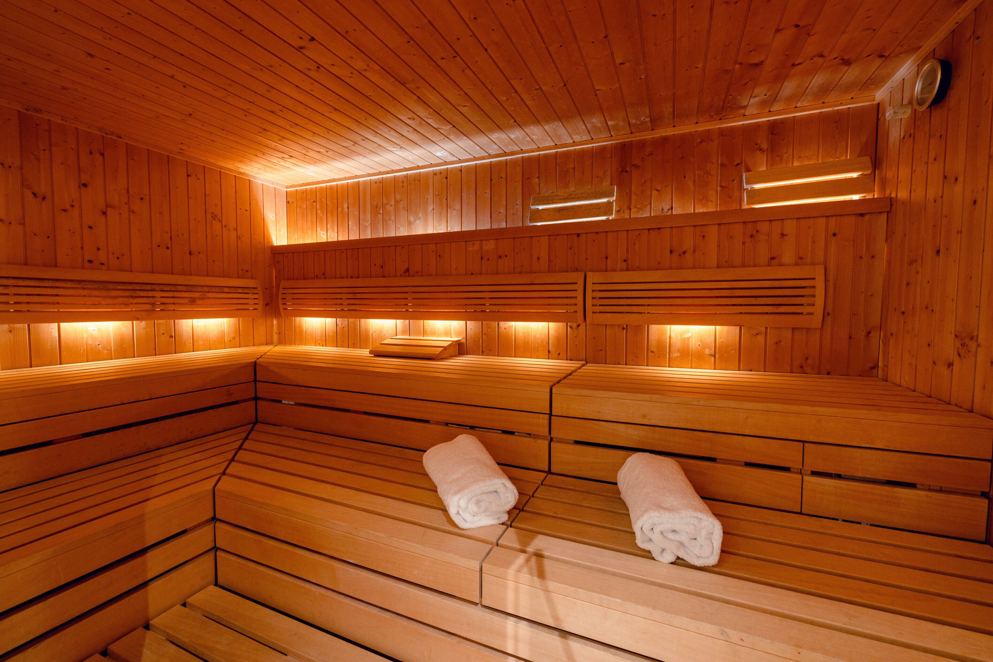 Eine Sauna mit Holzbänken und Handtüchern darauf.