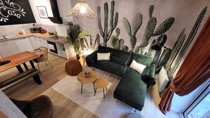 A modern living room with a green sofa, two round coffee tables, and a dining area with a wooden table and chairs. - Home Antonin & Maye: 6 travelers - 3 bedrooms - 2 bathrooms - Terrace (TONNERRE)