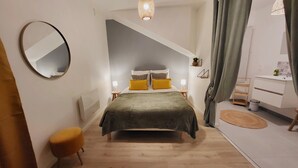 A bedroom with a bed, a round mirror, a bedside table, a lamp, and a dresser. - Home Antonin & Maye: 6 travelers - 3 bedrooms - 2 bathrooms - Terrace (TONNERRE)