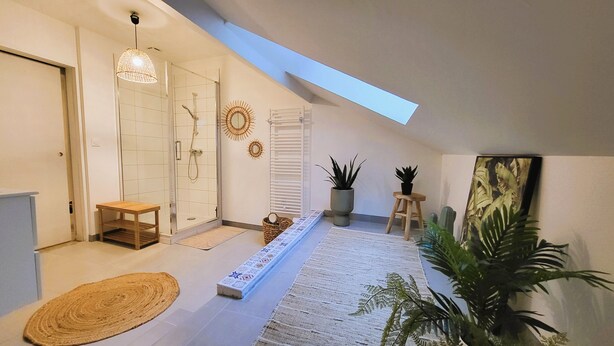 A modern bathroom with a glass shower enclosure, a wooden bench, a patterned rug, and a skylight. - Home Antonin & Maye: 6 travelers - 3 bedrooms - 2 bathrooms - Terrace (TONNERRE)