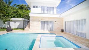 A modern two-story house with a swimming pool, a covered patio, and a staircase leading to the upper floor. - First Class 4br King Size Villa In Sosua Town! (Sosúa)