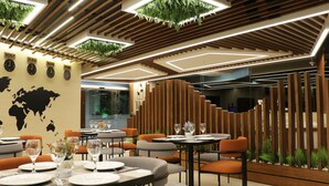 Interior moderno de restaurante con paneles de madera, plantas colgantes y un mapa mundial en la pared.