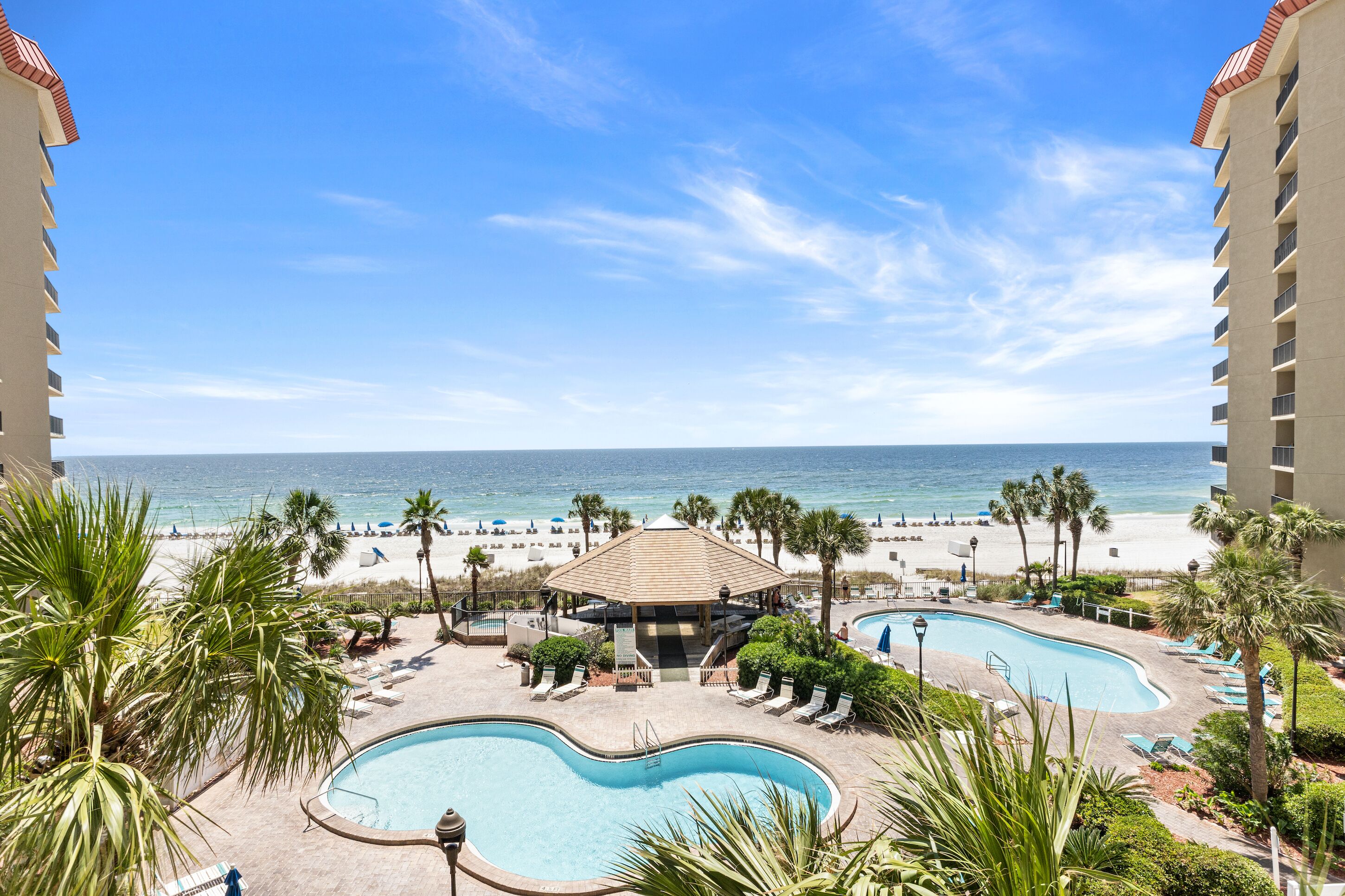 A resort with a pool area, beach, and ocean view.