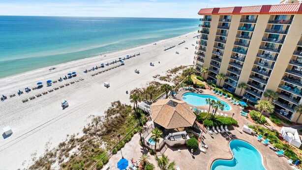 A beachfront hotel with a pool area, beach access, and multiple balconies.