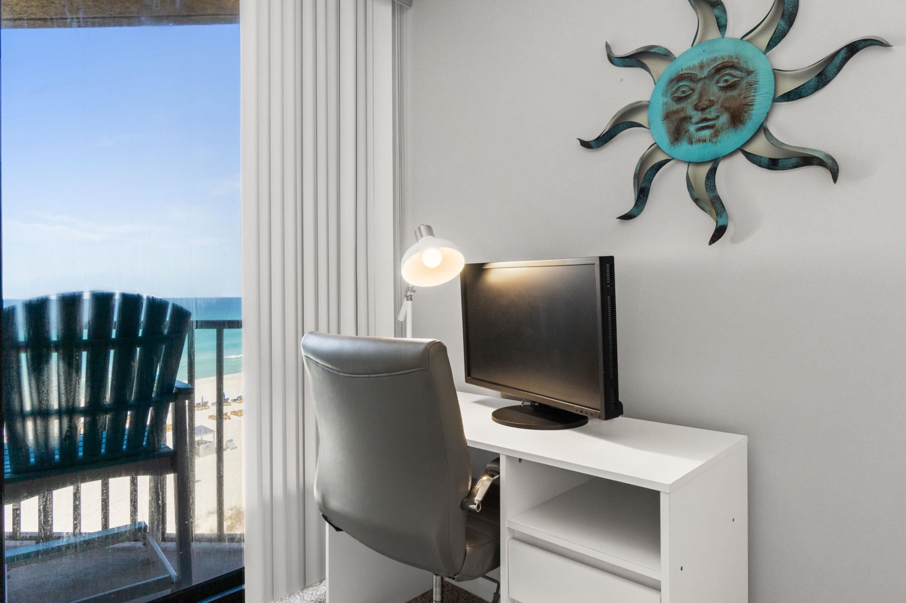 A room with a desk, chair, and a wall decoration.