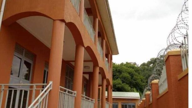 Un immeuble à la façade rouge, doté de nombreux balcons et de fenêtres grillagées.