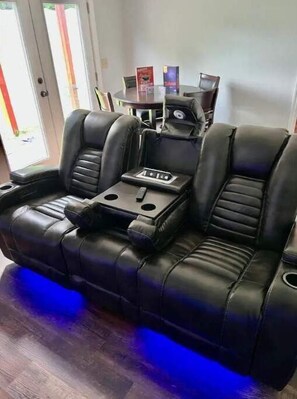 A black leather sofa with a center console, a glass table, and two boxes on the table. - The Winchester (Winchester)