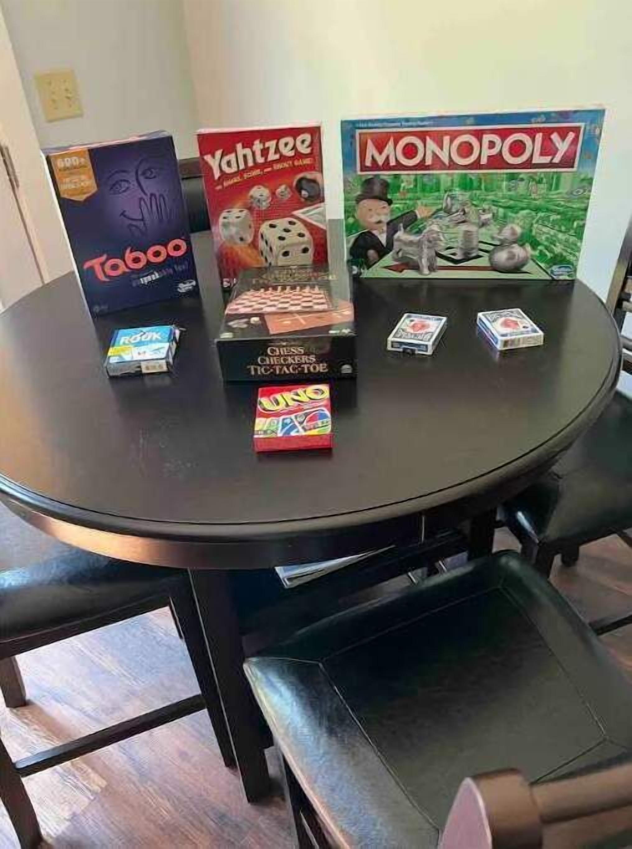 A table with board games including Taboo, Yahtzee, and Monopoly.
