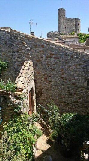 Set amidst lush gardens, this traditional building features a steeply pitched roof and arched doorway.