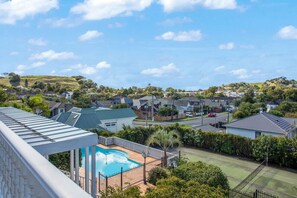 Uma área residencial com casas, piscina e quadra de tênis.