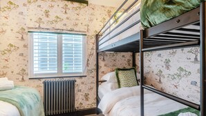 A bunk bed room with a radiator, a window with blinds, and wallpaper with a nature theme. - Perfect for a special occasion or get-together. (Medstead, near Alton)