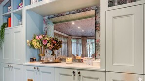 A room with light blue cabinets, a mirror, and a floral arrangement on the counter. - Perfect for a special occasion or get-together. (Medstead, near Alton)