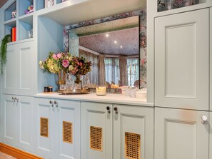 A room with light blue cabinets, a mirror, and a floral arrangement on the counter. - Perfect for a special occasion or get-together. (Medstead, near Alton)