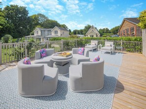 A deck with outdoor seating, a patterned rug, and a view of houses in the background. - Perfect for a special occasion or get-together. (Medstead, near Alton)