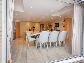 A modern kitchen with a dining area, wooden flooring, and a clock on the wall. - Perfect for a special occasion or get-together. (Medstead, near Alton)