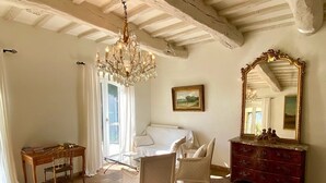 A room with a bed, a desk with a chair, a dresser, a chandelier, and a large mirror. - Mas Provençale Entouré de Pommiers, Piscine et Terrain de Tennis (Cavaillon)