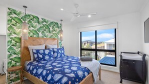 A bedroom with a bed, a window, a ceiling fan, and a TV. - The Beach House on Pembrey (Cowes)