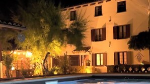 Ein Schwimmbecken bei Nacht mit einem Gebäude im Hintergrund.