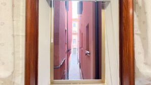 A narrow hallway with red walls and a wooden door frame.