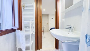 A bathroom with a white sink, a mirror, and a shower.