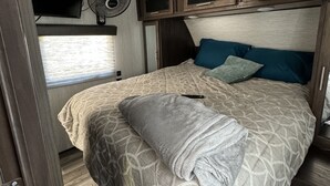 A bedroom with a bed, a TV, and a ceiling fan. - 26FT CAMPER IN THE BEST FISHING/HUNTING SECRET IN SC (Iva)