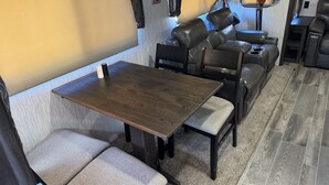 A compact RV interior with a dining area, seating, and a small kitchenette. - 26FT CAMPER IN THE BEST FISHING/HUNTING SECRET IN SC (Iva)