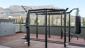 An outdoor gym with a punching bag and pull-up bar, set against a mountainous backdrop. - Bright Studio With City Views - No Load-shedding (Cape Town)