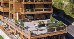 A multi-story wooden building with outdoor seating and a balcony. - Das Förstereck (Viehhofen)