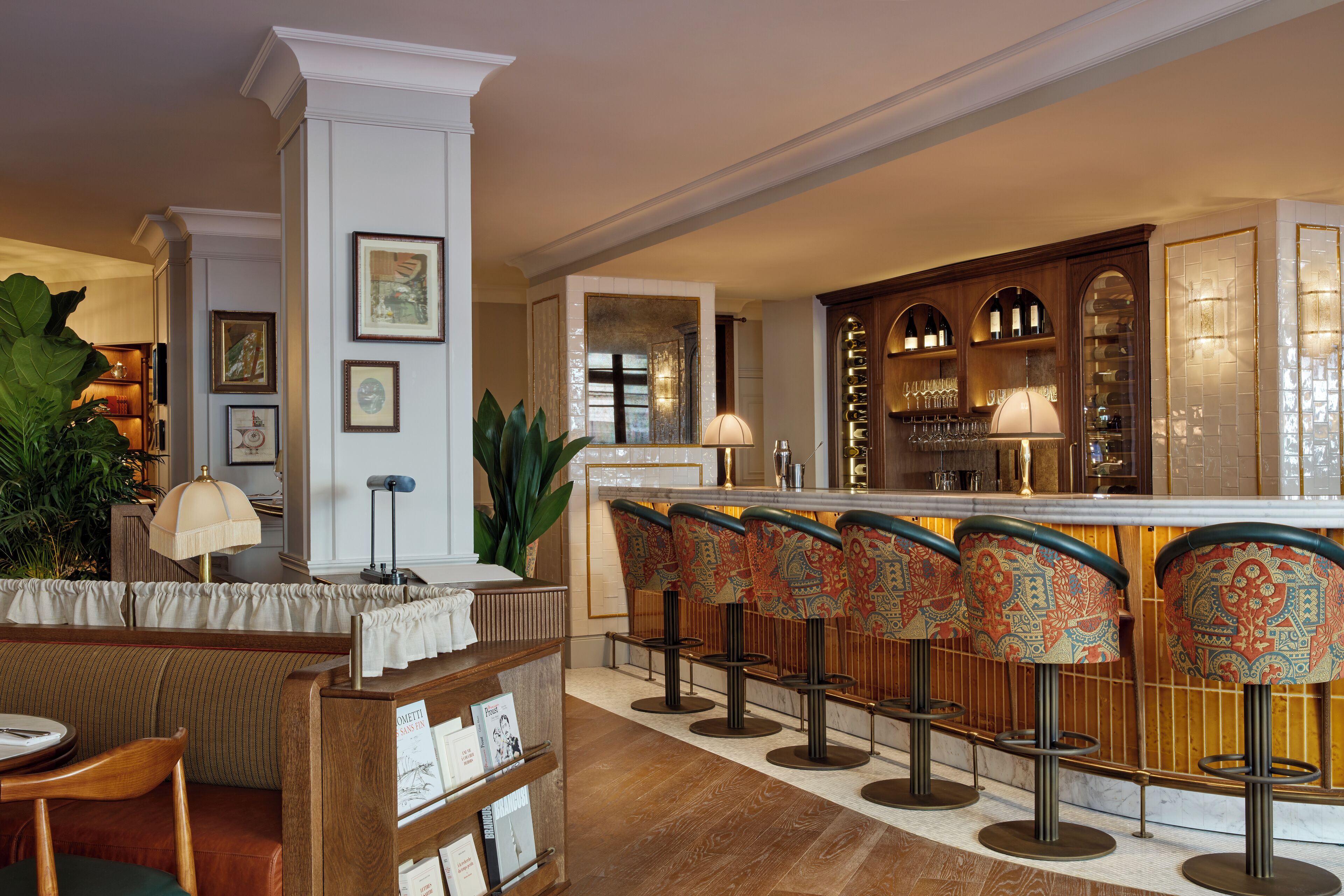 A bar area with a counter, bar stools, and a seating area with a table and chairs.