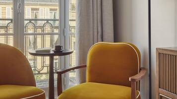 A room with a yellow armchair, a small round table, and a floor lamp.