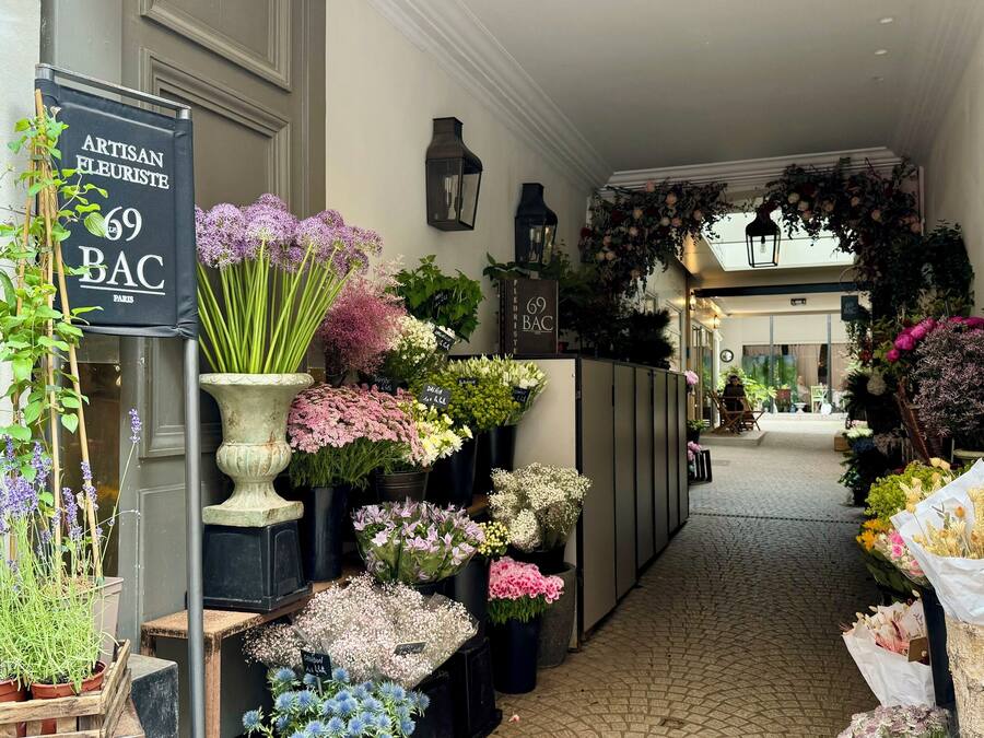 Una floristería con diversas plantas y flores exhibidas en su escaparate.
