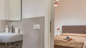 A modern bathroom with a sink, mirror, and towel dispenser. - Casa del Golfo Cascio 3 Secondo Piano (Castellammare del Golfo)